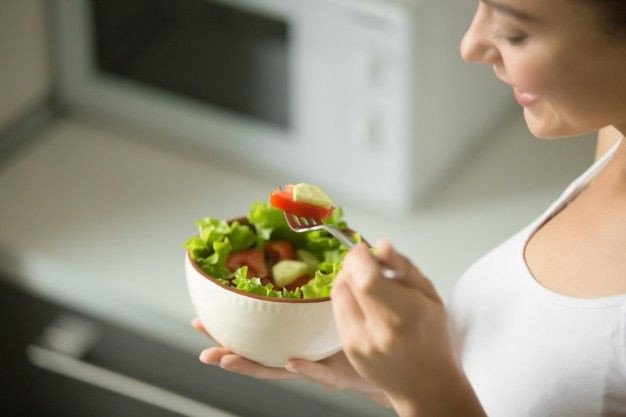 Seorang wanita sedang makan salad.